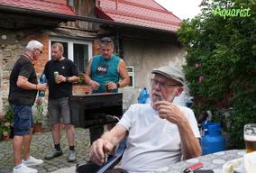 Posezení u stolečku (Luděk Zicháček) a grilování (Luboš Guhl). Diskuze v pozadí Jarda Dvořák a Jiří Kudrna.